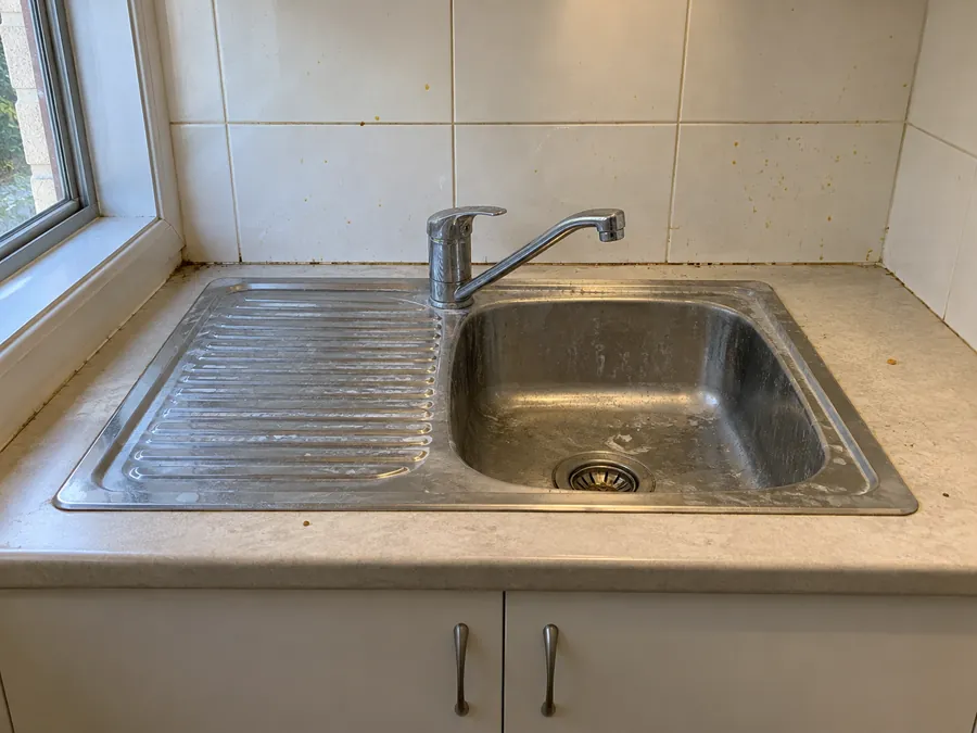 Marked kitchen sink and splashback before an end of lease clean in Sydney