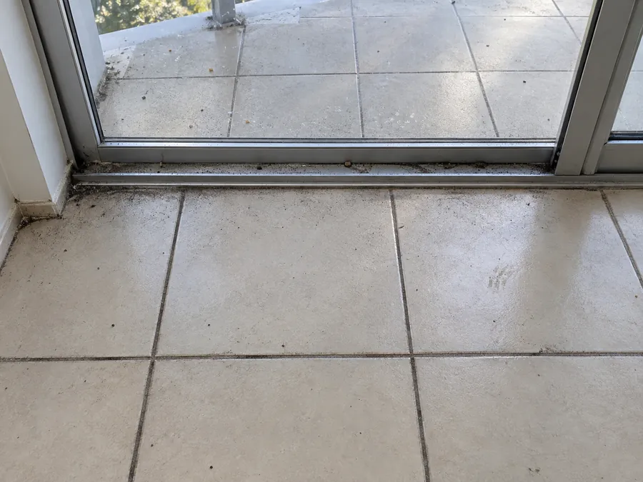 Dirty tiled floor and balcony track before an end of lease clean in Sydney