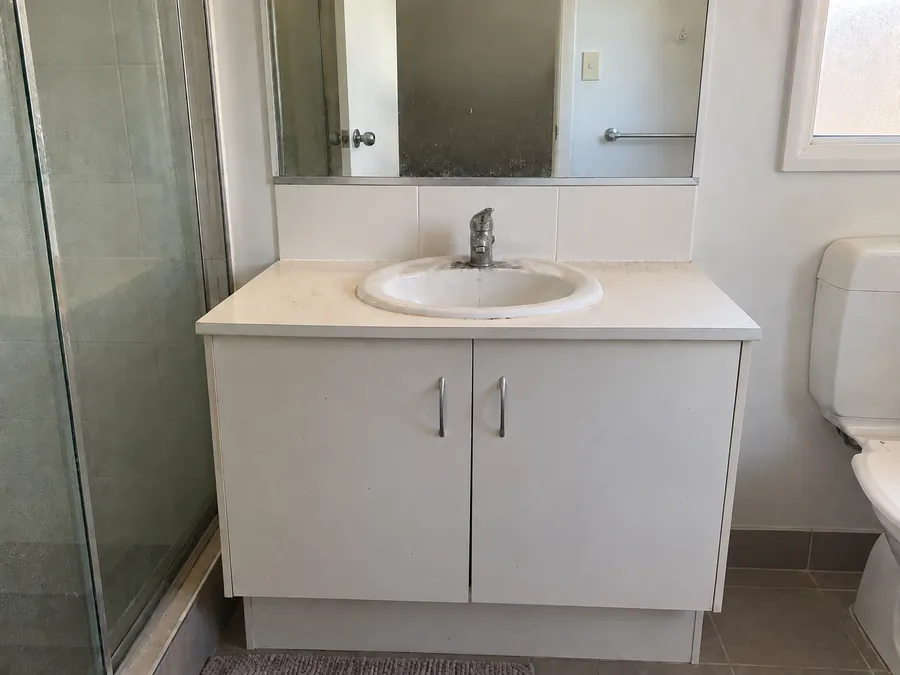Marked bathroom vanity and mirror before an end of lease clean