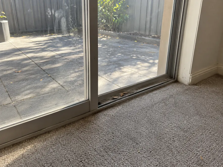 Dirty sliding glass door track before an end of lease clean