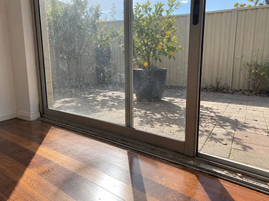 Dirty sliding glass door and track before a Perth vacate clean